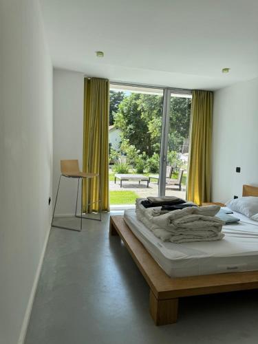 une chambre avec un lit et une grande fenêtre dans l'établissement Villa contemporaine vue mer - Maison d'architecte, au Pouliguen