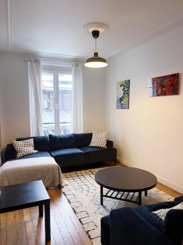 un salon avec un canapé et une table dans l'établissement Stylish and bright apartment 35m2 Paris 11ème, à Paris