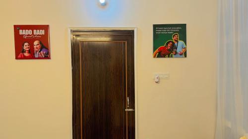two posters on a wall next to a door at Patna Backpackers in Patna