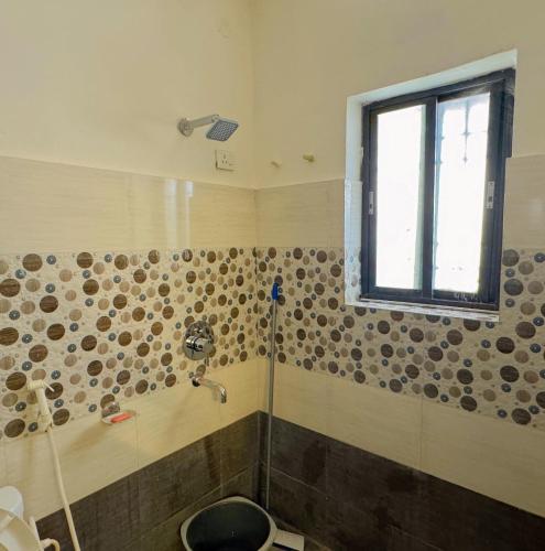 a bathroom with a shower and a window at Patna Backpackers in Patna