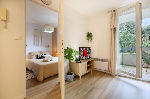 une chambre avec un lit et une grande fenêtre dans l'établissement Le Tropical Bali, Appt T2, proche métro et centre ville, à Toulouse