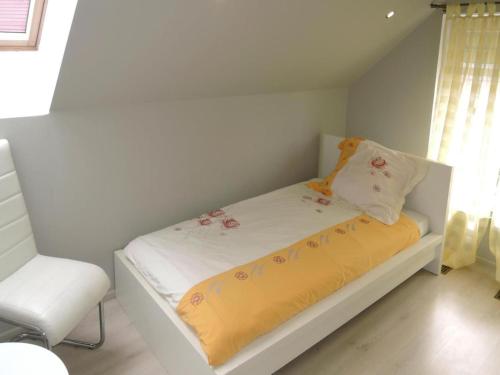 a small bed in a room with a chair at Family House near Baltic Sea and Szczecin Lagoon in Dargobądz