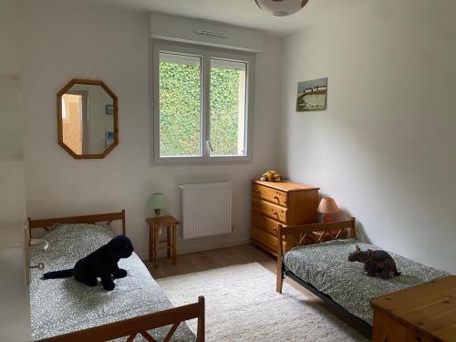 a bedroom with two beds and a dog laying on them at Gîte la clé des champs in Bueil
