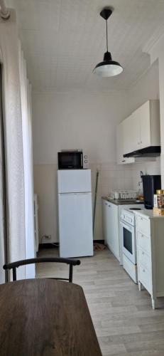 - une cuisine avec des appareils électroménagers blancs et une table dans l'établissement NICE STUDIO 26m2 avec TERRASSE 16m2, à Nice