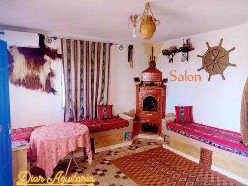 a room with a table and a stove in a room at Diar Aquilaria Dar Narjes in El Haouaria
