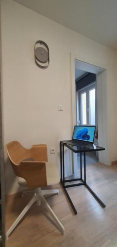 a office with a desk and a chair and a laptop at DM apartman Beograd in Vračar (historical)