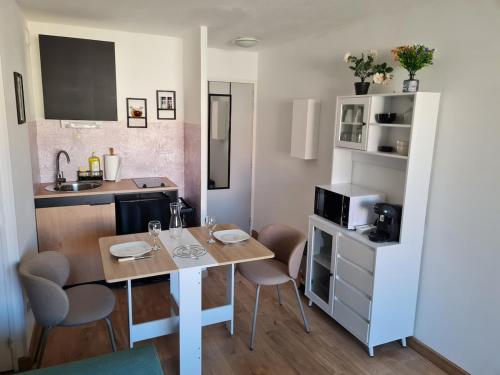 une petite cuisine avec une table et des chaises dans une pièce dans l'établissement Appartement T2 proche gare et centre ville, à Sète