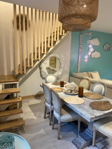 une salle à manger avec une table et des chaises et un escalier dans l'établissement Duplex quatre pièces - une chambre bébé à 5 minutes de la plage, à Nice