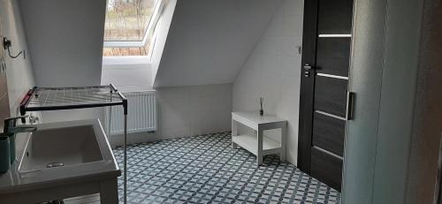 a small bathroom with a sink and a window at Chalupa Čtyřlístek in Husinec