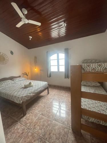 una camera da letto con due letti e un ventilatore a soffitto di Casa Tucano a São Sebastião
