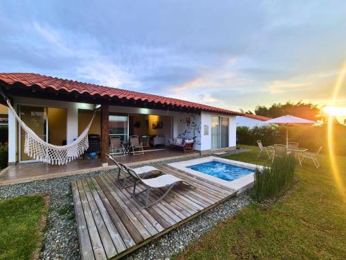 a house with a deck and a swimming pool at Casa Campestre en zona exclusiva con Jacuzzi, a 10 min del aeropuerto, 20 min parque del café, WiFi, parqueadero privado, vigilancia 24 hrs y amplias zonas sociales in Armenia