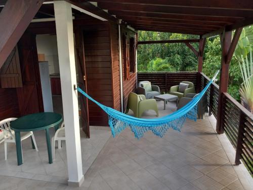 a hammock on the porch of a house at Location Bellevue - Corossol in Saint-Louis