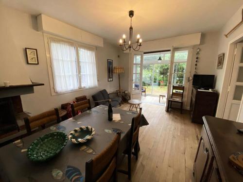 un salon avec une table et des chaises et une salle à manger dans l'établissement Résidence 043-soulac Sur Mer - 043 - Charmante maison avec jardin à 80 m de la plage MAE-9631, à Soulac-sur-Mer