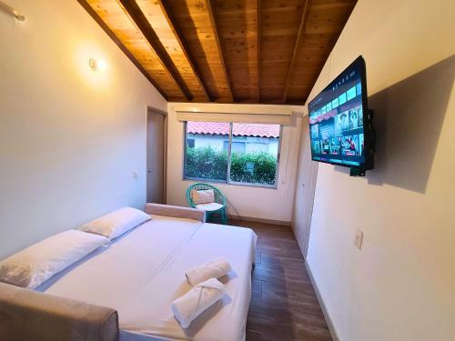 a bedroom with a large bed and a flat screen tv at Casa Campestre en zona exclusiva con Jacuzzi, a 10 min del aeropuerto, 20 min parque del café, WiFi, parqueadero privado, vigilancia 24 hrs y amplias zonas sociales in Armenia
