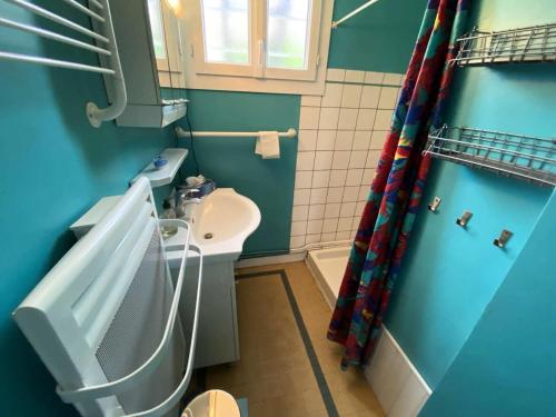 une salle de bain bleue avec un lavabo et des toilettes dans l'établissement Résidence 043-soulac Sur Mer - 043 - Charmante maison avec jardin à 80 m de la plage MAE-9631, à Soulac-sur-Mer