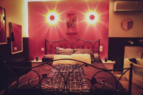a bedroom with a bed with lights on the wall at Osez! Le fruit défendu Loveroom Carpentras in Carpentras