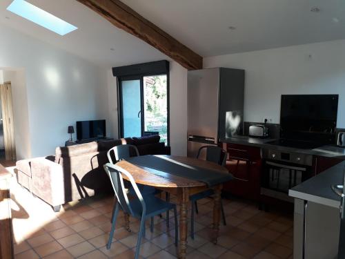 une cuisine et un salon avec une table et des chaises dans l'établissement Gite cure thermale Jonzac, à Antignac