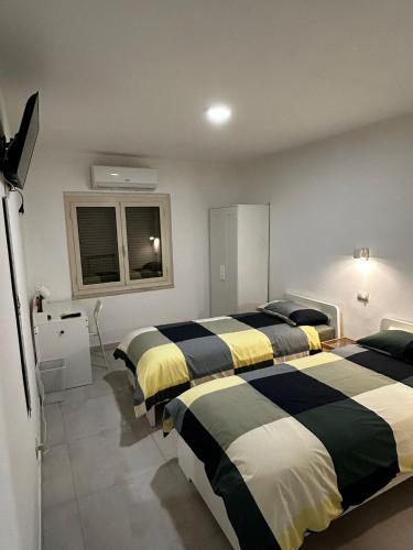 a bedroom with two beds and a window at b&b IL MELOGRANO in Celenza sul Trigno