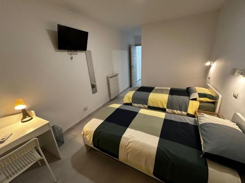 a bedroom with a bed and a desk and a television at b&b IL MELOGRANO in Celenza sul Trigno