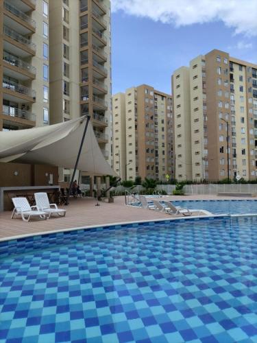 a swimming pool with a tent and some buildings at Apartamento en Villeta Hermoso in Villeta