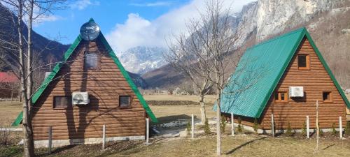 a small wooden house with a green roof at Eco resort Komarnica in Šavnik