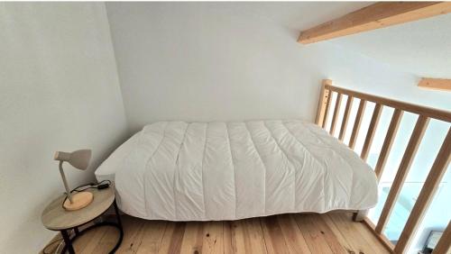 une chambre avec un lit et une table avec une lampe dans l'établissement Appartement 1 Chambre CARPE DIEM, à Jonzac