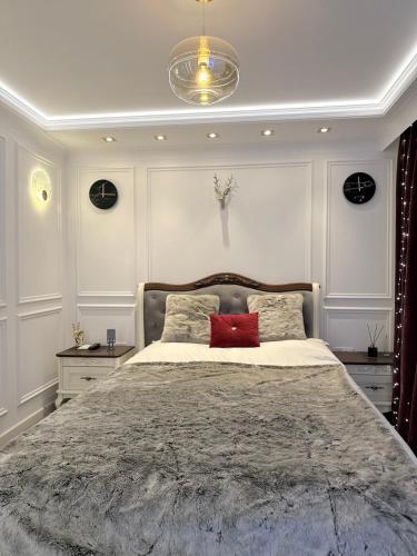 a bedroom with a large bed with a red pillow at Private Bedroom in Unique Luxury House, Salford, Manchester in Manchester