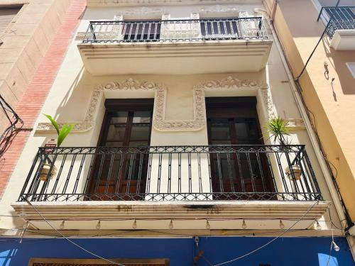 a building with a balcony with two plants on it at Apartamentos de la Casa Ducal in Gandía