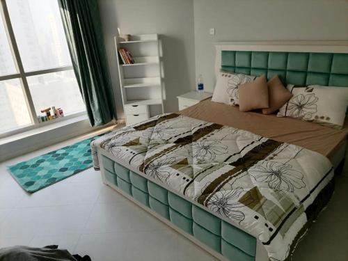 a bedroom with a large bed with a green headboard at Majaz3 in Sharjah