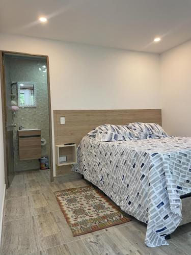 a bedroom with a bed and a walk in shower at Pachaea Hotel campestre in La Vega