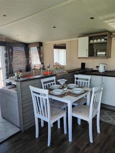 a kitchen and dining room with a table and chairs at Green House Moselle in Jaywick Sands
