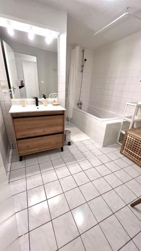 La salle de bains est pourvue d'une baignoire, d'un lavabo et d'une coiffeuse. dans l'établissement L'escapade Vosgienne, à Cornimont