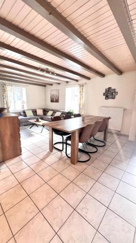 Cette grande chambre dispose d'une table et d'un canapé. dans l'établissement L'escapade Vosgienne, à Cornimont