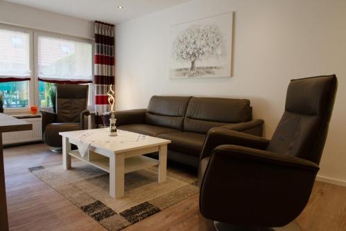 a living room with a couch and chairs and a table at Olivia in Norden