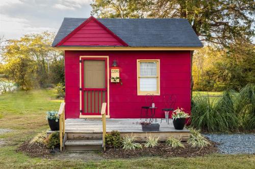 a red tiny house with a wooden porch at Cape Charles Tiny Livin' in Cape Charles