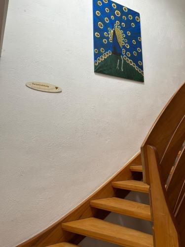 a painting of a blue bird on the wall next to a staircase at Ferienwohnung Schmalental in Barntrup