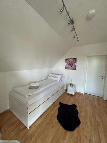 a white bed in a room with a wooden floor at Ferienwohnung Schmalental in Barntrup