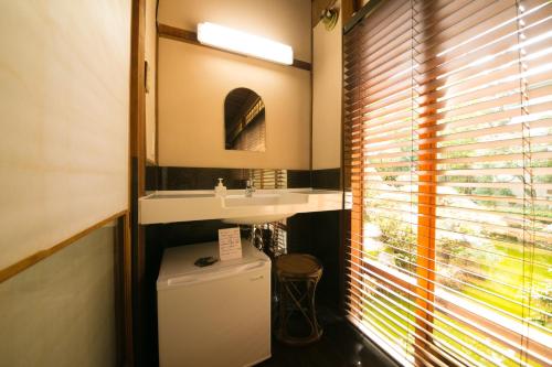 a bathroom with a sink and a window at Ryokan Sennari (13 years or older) in Beppu