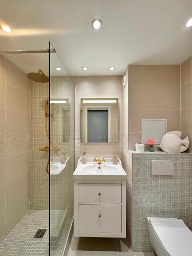 une salle de bain avec un lavabo et une douche en verre dans l'établissement Vue mer imprenable, piscine à débordement - Cannes, à Cannes