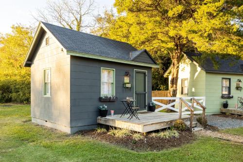 a small shed with a wooden porch in a yard at Cape Charles Tiny Livin' in Cape Charles