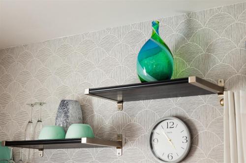 a shelf with a vase and a clock on it at Cape Charles Tiny Livin' in Cape Charles