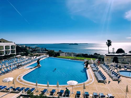 une piscine avec des chaises et l'océan en arrière-plan dans l'établissement Vue mer imprenable, piscine à débordement - Cannes, à Cannes
