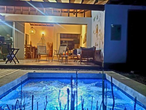 a swimming pool in front of a house at Casa Campestre en zona exclusiva con Jacuzzi, a 10 min del aeropuerto, 20 min parque del café, WiFi, parqueadero privado, vigilancia 24 hrs y amplias zonas sociales in Armenia