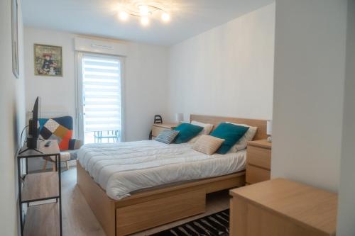 une chambre avec un lit avec des oreillers bleus dans l'établissement Les deux vallées, appartement neuf en résidence, à Pinchefalise