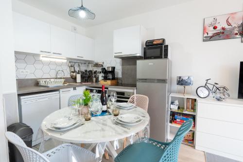 une cuisine avec une table et des chaises dans une cuisine dans l'établissement Les deux vallées, appartement neuf en résidence, à Pinchefalise