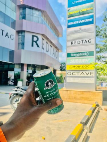 a person holding a cup of coffee in front of a building at Triple A visitors in Kilindoni