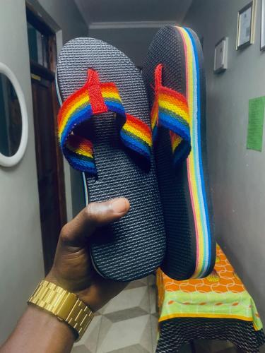 a person holding up a pair of flip flops at Triple A visitors in Kilindoni