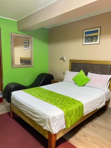 a bedroom with a large bed with a green wall at Hotel SPRING in Lima
