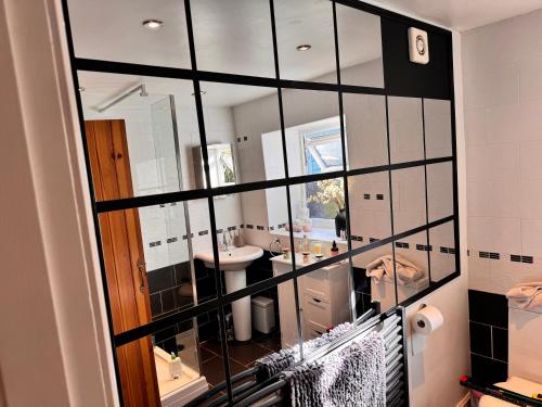 a bathroom with a mirror and a sink at Lilac Cottage in Farington