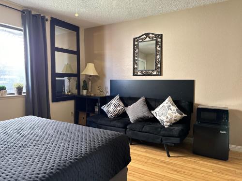 a bedroom with a bed and a couch and a mirror at Le Noir, A private bedroom with a private entrance - shared bathroom in Las Vegas